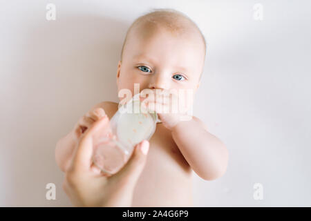 Un ritratto di carino neonato essendo alimentato da sua madre utilizzando la bottiglia. Foto Stock