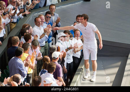 Andy Murray festeggia con la sua squadra dopo aver vinto il torneo di Wimbledon 2013. 77 anni di tennis male giunge al termine. Foto Stock