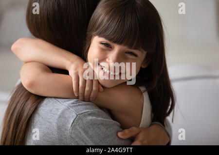 Colpo alla testa close up ritratto felice bambina coccole mamma. Foto Stock