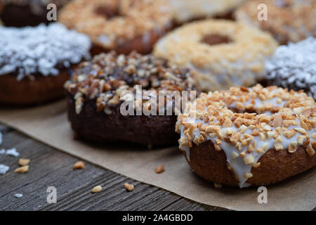 La Ganache ciambelle vetrata, spruzzata con vari noci frantumate Foto Stock