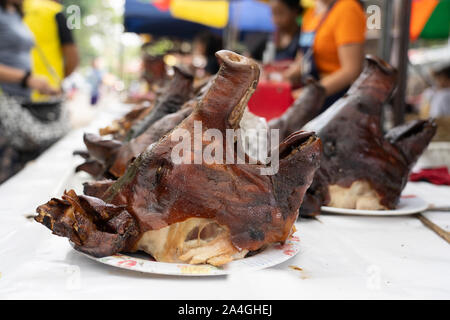 Arrosto di maiale teste per la vendita ad una bancarella di strada a Talisay city,Cebu. Foto Stock