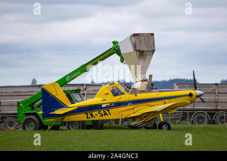 Sheffield, Canterbury, Nuova Zelanda, 14 Ottobre 2019: un prodotto giallo duster, o top dressing piano, viene riempito con il fertilizzante a disperdersi in fattoria Foto Stock