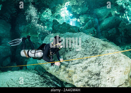 Un subacqueo esplora la grotta dei passaggi di Messico la famosa Dos Ojos cenote. Foto Stock