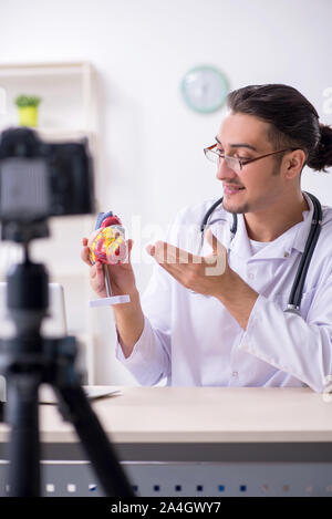 Il giovane maschio medico cardiologo di registrazione di video per il suo blog Foto Stock