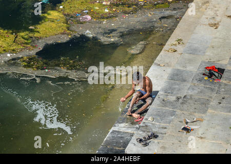 Udaipur, India - 17 Febbraio 2019: ragazzo indiano il lavaggio nel lago Swaroop sagar lago in Udaipur. Rajasthan Foto Stock