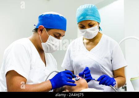 Dentista e il suo assistente di effettuare un esame approfondito Foto Stock