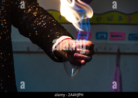 Il mago mostra trucco con il fuoco brucia da palme delle mani. Foto Stock