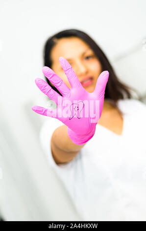 Dentista donna che mostra la sua mano con un dente disegno, concetto dentale Foto Stock