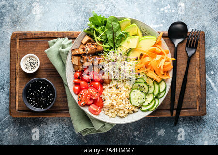 Ciotola di Buddha con tofu, avocado, bulgur grani, il cetriolo, la carota e il pomodoro guarnito con semi e micro verdi. Vegano sano e cibo vegetariano, t Foto Stock