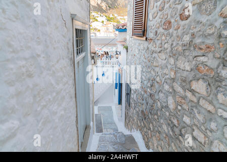 Hydra, isola greca - 20 luglio 2019; stretto vicolo giù per balcone ristorante con pareti dipinte di bianco e blu di Windows e decorazioni. Foto Stock