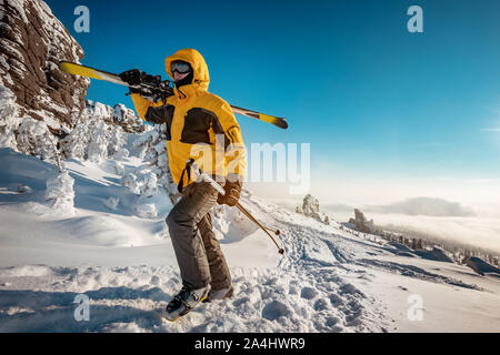 Sciatore con sci in mani va in salita per lo sci backcountry. Ski resort concept Foto Stock