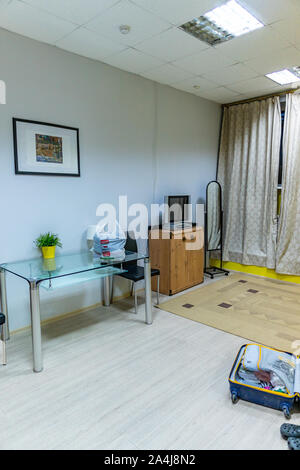 Ostello di classe inferiore piano terra Camera da letto con un tavolo in vetro e una TV su una scheda Foto Stock