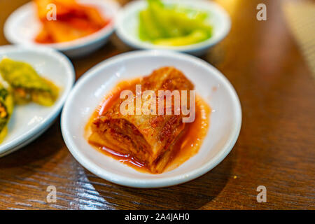 Primo piano di una succulenta piccante e saporito tritate Fette di kimchi coreano su una piastra bianca Foto Stock