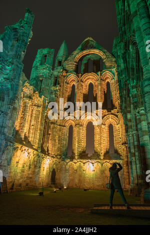 Una spettacolare display luminoso illumina la storica Abbazia di Whitby nel mese di ottobre 27, 2015 a Whitby, Inghilterra. La famosa abbazia benedettina sarà illuminata per quattro notti a coincidere con Halloween e la popolare Whitby Goth Weekend. Durante questo periodo di tempo i visitatori per la storica tradizione inglese posizione vedrà l'abbazia inondate di luce spettacolari come pure vivendo il sito dopo il tramonto La Abbazia fu parte di ispirazione per Bram Stoker's romanzo, Dracula e siede sulla East Cliff di città in una posizione di comando che si affaccia sul Mare del Nord. Foto Stock