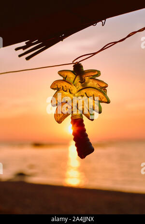 Palm tree sagomato luce stringa decorare un rustico bar sulla spiaggia cafe con un tramonto cielo e mare spiaggia sfondo - estate tropicale spiaggia paradiso di vacanza Foto Stock