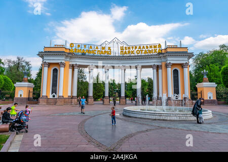 Almaty Central Park Gate principale ingresso vista frontale con fontana e i visitatori su un soleggiato nuvoloso cielo blu giorno Foto Stock