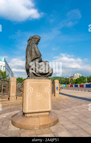 Almaty un monumento di indipendenza statua di una seduta il kazako donne su un soleggiato nuvoloso cielo blu giorno Foto Stock