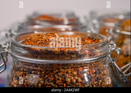 Spezie fragranti in un vasetto di vetro con un coperchio e un blocco di metallo. Close up Foto Stock