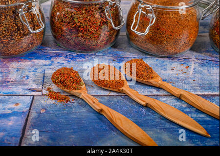 Spezie fragranti in cucchiai di legno e barattoli di vetro sul tavolo Foto Stock