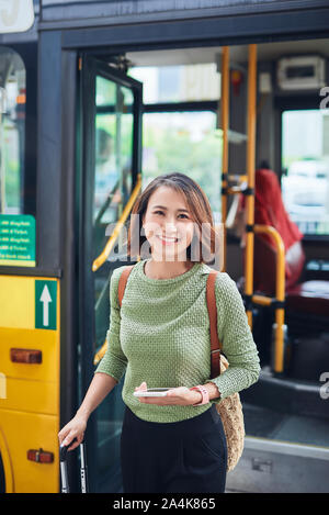 Un viaggiatore asiatici andando fuori il bus terminal Foto Stock
