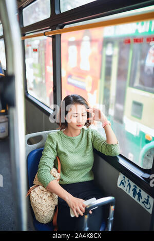 Passeggero viaggia e sensazione di vertigini con mal di testa in un viaggio in autobus Foto Stock