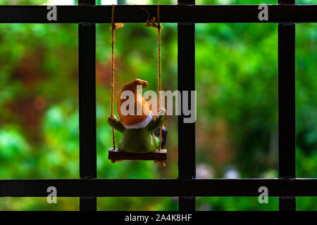 Nana in lo swing alla finestra. Autunno sfondo. Foto Stock