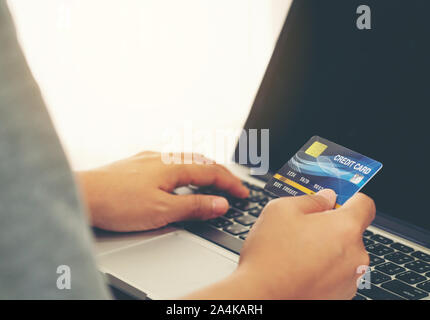 Donne usa carta di credito per gli acquisti online a casa sua Foto Stock