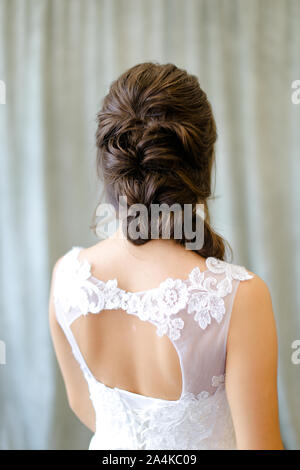 Vista posteriore di bruna sposa con treccia di capelli foto in studio. Foto Stock