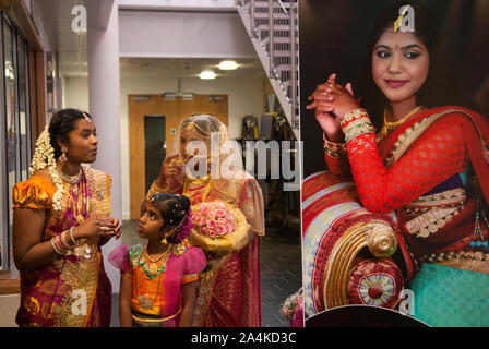 Festa di celebrazione Hindu Coming of Age Londra Regno Unito la fotografia espositiva è della giovane donna. E' a sinistra e indossa un velo per la prima volta con i parenti. Ha 16 anni. Mitcham a sud di Londra, Regno Unito, accoglieranno gli ospiti al grande Ritushuddhi, chiamato anche Ritu Kala Samskara Party. Una celebrazione e la transizione alla femminilità. 2010S 2016 UK HOMER SYKES Foto Stock