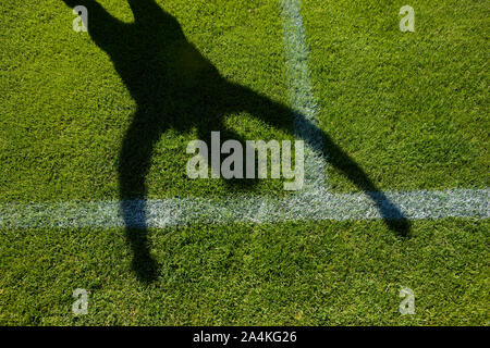Ombra di gioiosa persona nel campo di calcio Foto Stock