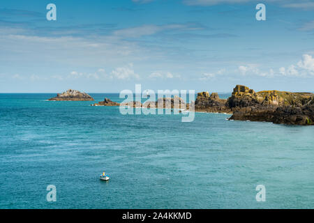 Una vista della costa rocciosa e oceano paesaggio con un pescatore solitario in una piccola barca Foto Stock