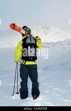 Sciatore che guarda oltre le montagne nevose a Hemsedal, Norvegia Foto Stock
