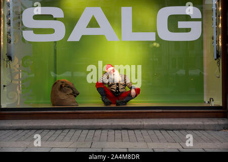 Santa Claus in appoggio in un negozio di vendita finestra Foto Stock