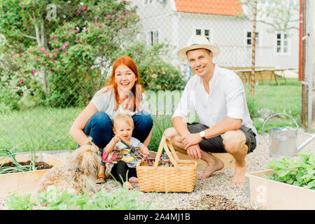 I genitori con baby boy lavora in giardino Foto Stock