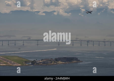 Rio de Janeiro, Brasile - 28 Marzo 2016: aereo in fase di decollo su punti di riferimento della città - Aeroporto Santos Dumont, Ponte Rio-Niteroi e Baia Guanabara Foto Stock