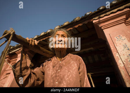 Hoi An, Quang Nam Provincia, Vietnam - Febbraio 24, 2011: Senior donna vietnamita vende frutta per turisti nel centro storico di Hoi An Foto Stock