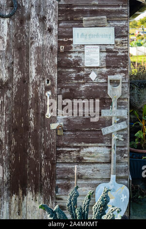 Un eccentrico weathered Tettoia da giardino con un vecchio spade e slogan Foto Stock