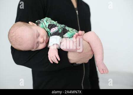 Il bambino che dorme sul braccio di padri Foto Stock