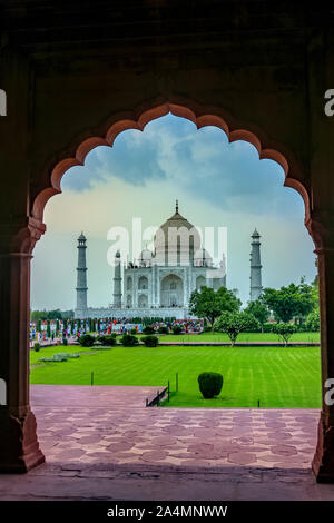 Il Taj Mahal al tramonto, visto attraverso un arco in architettura di Mughal, Agra, India Foto Stock