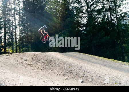 Savognin, GR / Svizzera - il 12 ottobre, 2019: downhill mountain biker jumping alta e equitazione hard a Lenzerheide nelle Alpi Svizzere Foto Stock