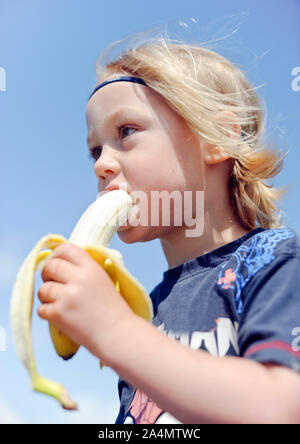 Ragazzo di mangiare banana Foto Stock