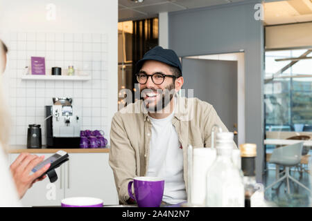 Uomo sorridente in ufficio caff Foto Stock
