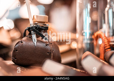 E vittoriano steampunk ispirato la scrittura imposta. Vecchio inkwell e penna del cappello realizzato al di fuori di un uccello reale giù. In pelle e dettagli in ottone. Fatto a mano. Foto Stock