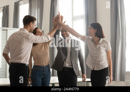 Diversi team di dipendenti dando alta cinque, celebrando il successo Foto Stock