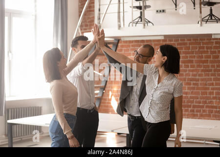 Diversi dipendenti dando alta cinque, celebrando il successo i risultati del lavoro Foto Stock