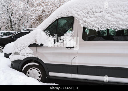 Prima nevicata. Coperte di neve vetture dopo una nevicata improvvisa. Inverno in città Foto Stock