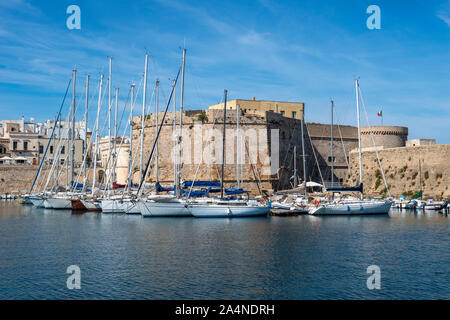 Vista sul porto di yacht ormeggiati accanto al castello Angevine-Aragonese in Gallipoli città vecchia, Puglia (Puglia) nel Sud Italia Foto Stock