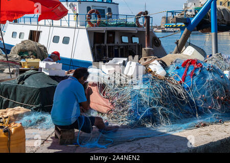 I pescatori rammendo reti sulla banchina del porto di Gallipoli, Puglia (Puglia) nel Sud Italia Foto Stock