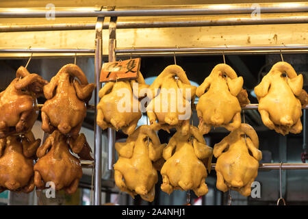 Arrosto di anatre e polli appesi a ganci Foto Stock