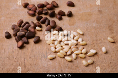 Gruppo di pinoli su sfondo di legno Foto Stock